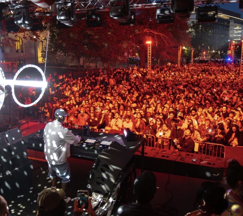 DJ performing to large outdoor crowd